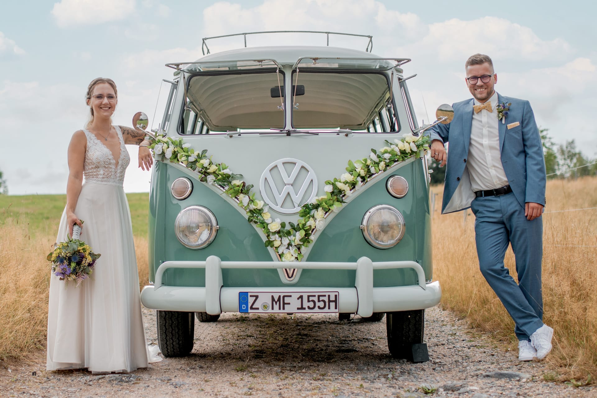 Autodekoration Standard mit Kunstblumen Girlande mit weißen Rosen und Blüten in creme mit Brautpaar an der Hochzeit als Hochzeitsauto